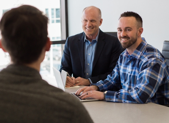 people sitting at at desk smiling