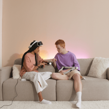 man and woman sitting on a couch with a VR headset