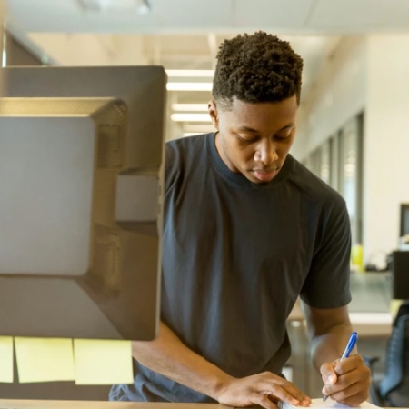 many taking notes at his desk