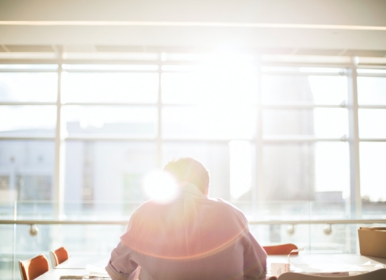 Man sitting at a desk with the sun rising
