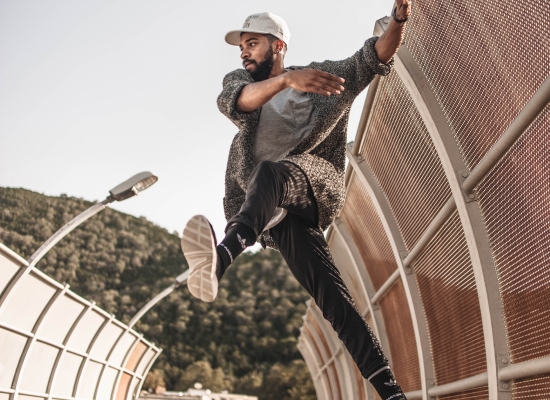 man dancing on a highway bridge