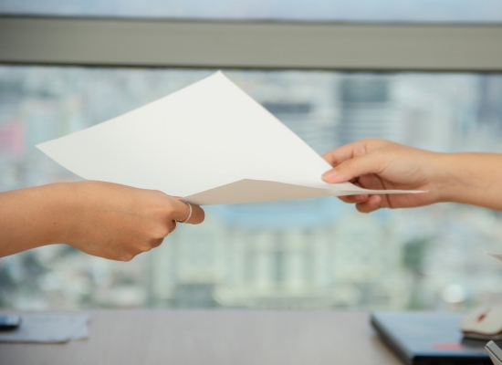 person handing another person a paper